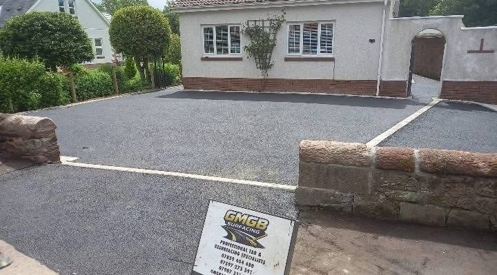 Completed tarmac with grey block edging and white stone feature
